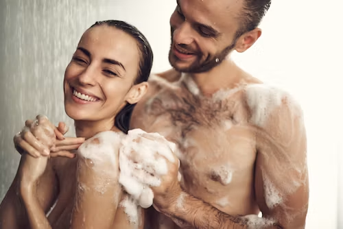 Couple smiling together in the shower — Hardwired For Pleasure relationship and intimacy context